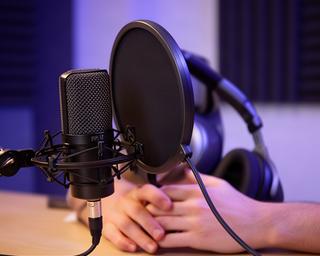 高音質マイクとヘッドホンを使った音声ポッドキャスト収録風景